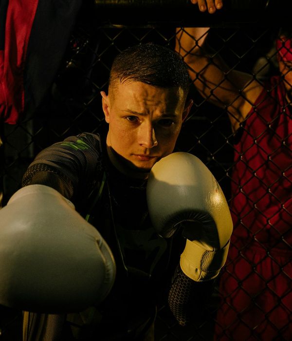 Man performing a strength exercise in a dark room with iris light.
